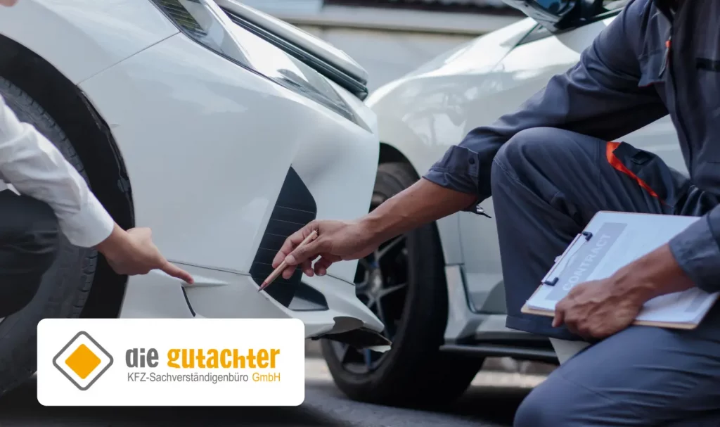 Zwei Personen, die neben einem weißen Auto knien, untersuchen den Schaden in der Nähe der vorderen Stoßstange und weisen darauf hin. Eine Person hält ein Klemmbrett in der Hand. In der Ecke sind das Logo "die gutachter KFZ-Sachverständigenbüro GmbH" und der Schriftzug "KFZ Gutachter Dresden" zu sehen.